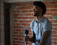 Man Sitting And Smiling With A Microphone Photo